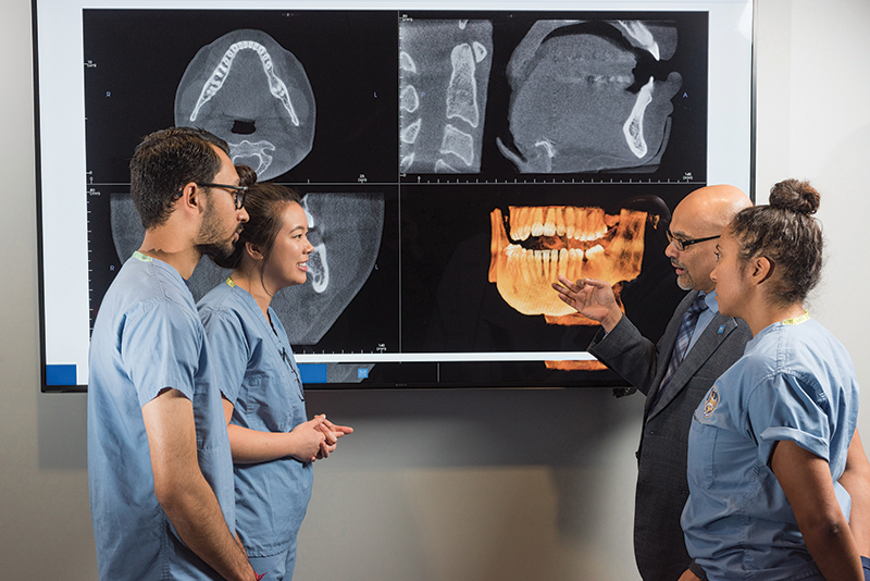 Dr. Sanjay Mallya with students reviewing CT scans