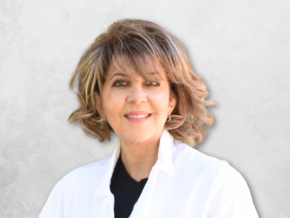 Dr. Mitra Elisha Simanian is wearing a white doctors coat over a black top